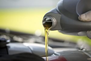 A closeup of motor oil being poured into an engine
